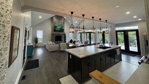 A spacious kitchen with a large island, dark cabinetry, and a stone fireplace. - Escape to Country Comfort

Perfect for a romantic escape, or family retreat. (Iroquois)