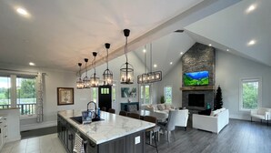 A spacious living area with a large island, dark wood flooring, and a stone fireplace. - Escape to Country Comfort

Perfect for a romantic escape, or family retreat. (Iroquois)