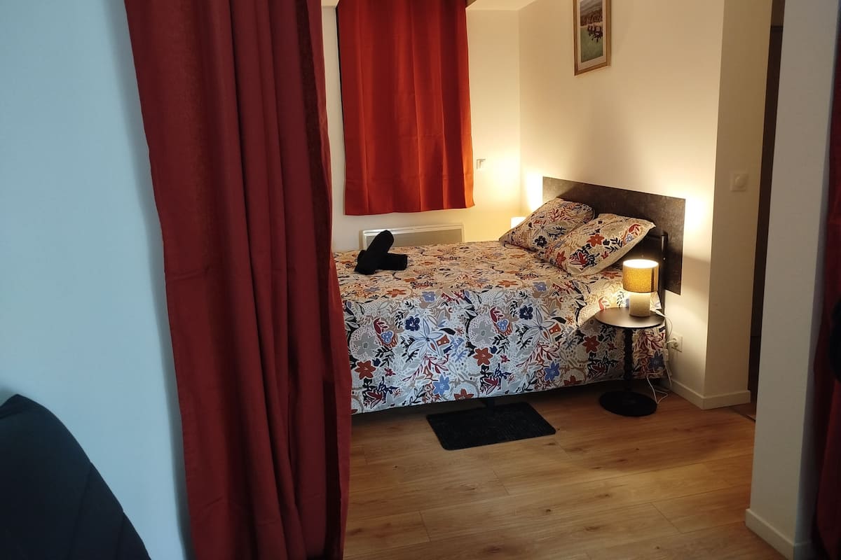 Quarto com cama, luminária de cabeceira e quadro na parede.