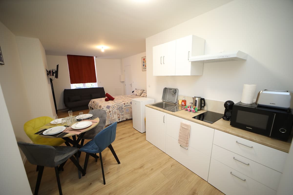 A compact kitchen with white cabinets, a microwave, and a small refrigerator.