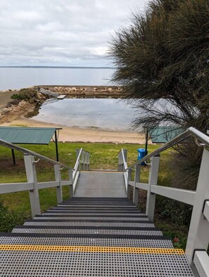 A set of outdoor stairs leading to a beach area with a view of the sea. - Sails: Family-friendly, in the heart of town (Kingscote)