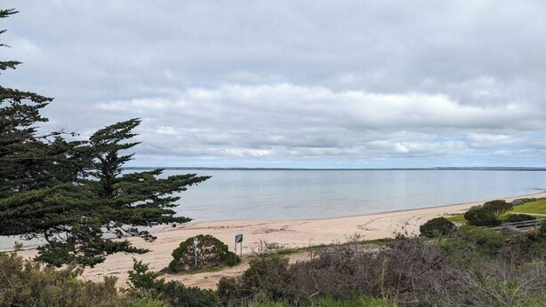 Una playa con un letrero que dice "The Yacht Club Beach".