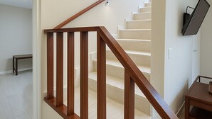 Een moderne trap met houten leuningen en beige wanden.