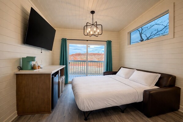 A bedroom with a bed, a TV, a desk, and a balcony with a view. - Ultra Luxury Tiny Home with Deck #59C (Page)