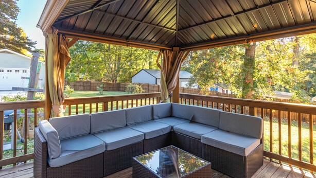Een overdekt terras met een modulaire bank en een salontafel met glazen blad.