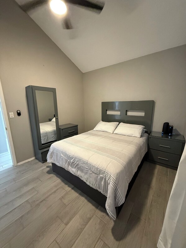 A bedroom with a bed, nightstands, a mirror, and a ceiling fan. - Enchanting 4-bedroom house with spacious backyard and pool in El Paso (El Paso)