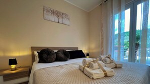 Un lit bien fait, avec une couverture matelassée, deux grands oreillers et des serviettes enroulées posées sur le lit.