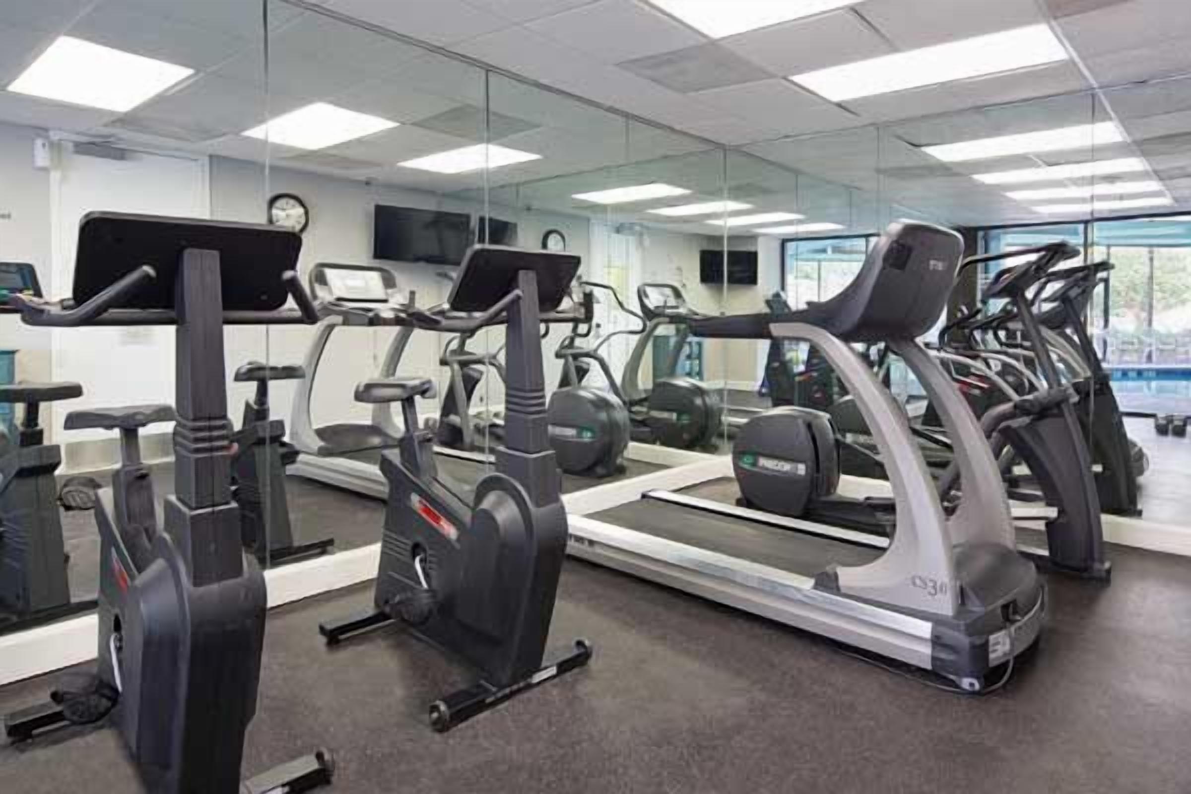 Ein Fitnessstudio mit Ergometer, Laufbändern und Trainingsgeräten.
