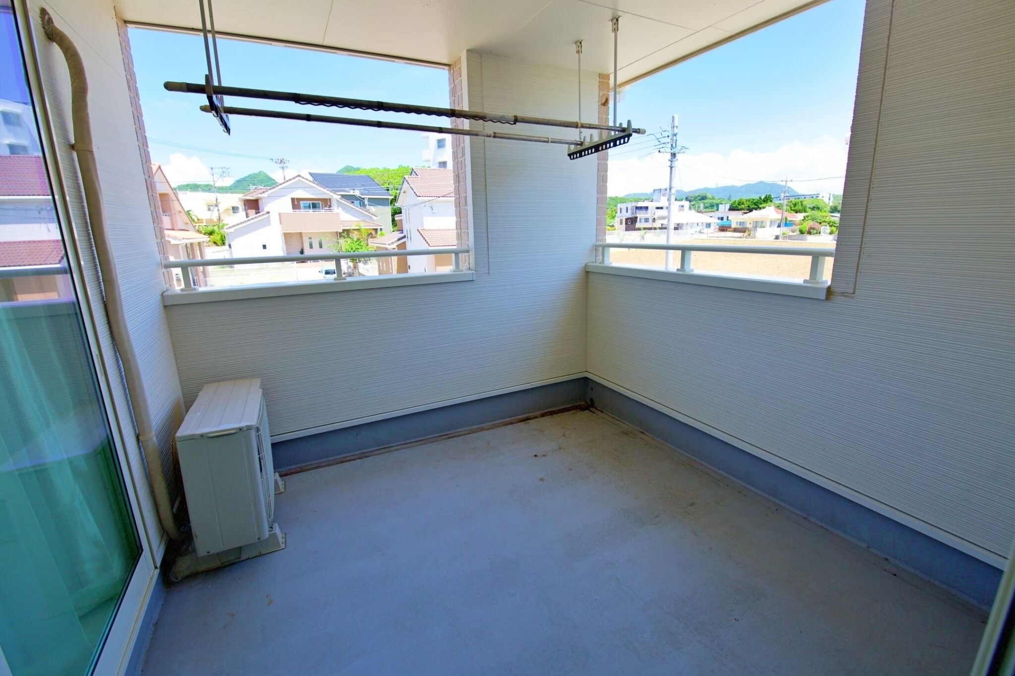 A room with two windows, a radiator, and a ceiling fan.