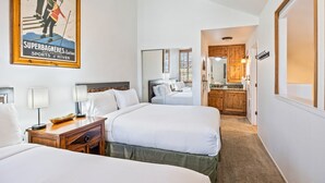 A hotel room with two beds, a wooden nightstand, a ceiling fan, and a poster on the wall. - Walk to Canyons Village Charm: Vintage-Inspired Interiors, Private Patio,  Shared Pool (Park City)
