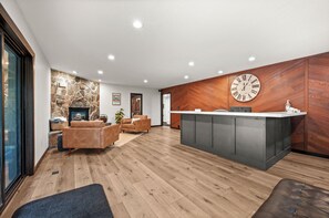 Ein moderner Empfangsbereich mit Steinwand, Holzvertäfelung, einer großen Uhr und einer Rezeption.