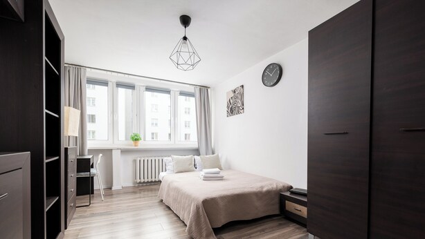 Un dormitorio con cama, escritorio y armario.