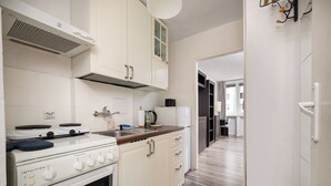 Una cocina con armarios blancos, estufa y microondas.