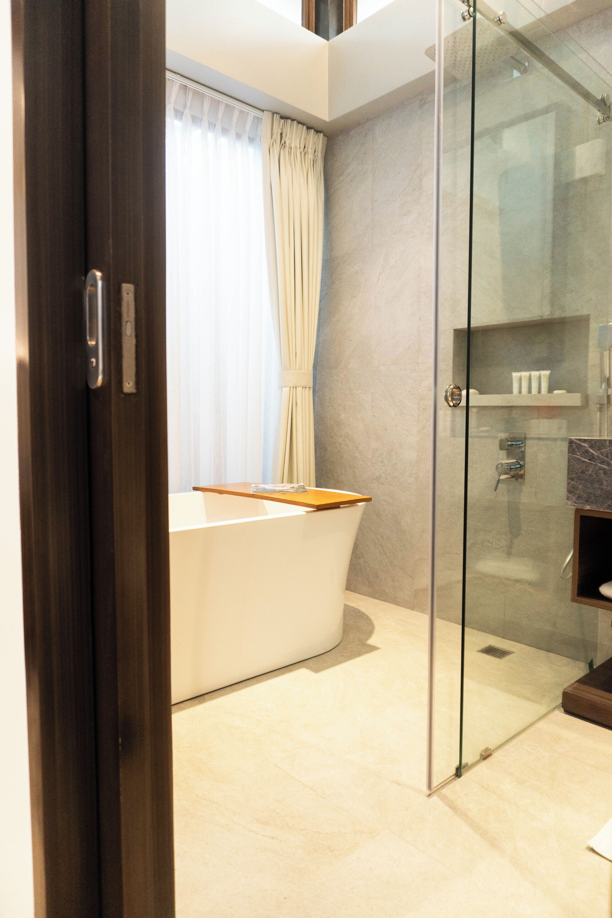 A modern bathroom with a glass shower enclosure, a bathtub, and a vanity.