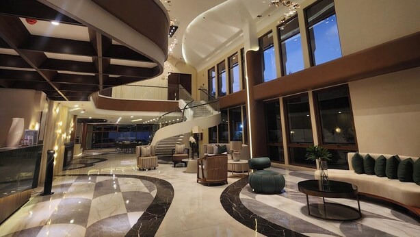 A spacious lobby with a central staircase, large windows, and a modern chandelier. - Brio De Agoho (Candelaria)