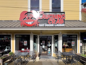 The exterior of The Laughing Crab restaurant with outdoor seating.