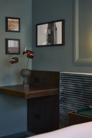 A reception desk with a vase of flowers, framed artwork on the wall, and a view of a building. - The Quiet 2 Bed - Calm, Low-Light Heritage Retreat (Auckland)