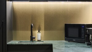 Una cucina moderna con un forno a microonde integrato, un rubinetto e una bottiglia sul piano di lavoro.