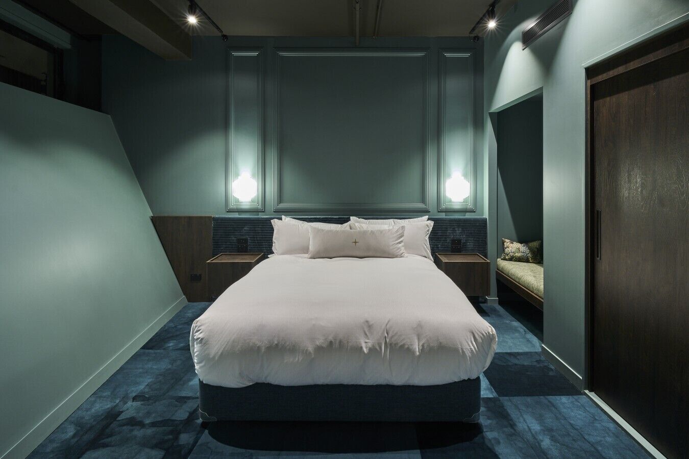 Une chambre à coucher avec un grand lit, deux tables de chevet, une commode et une armoire.