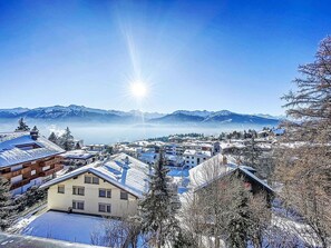 Vila coberta de neve com edifícios tradicionais e montanhas ao fundo.