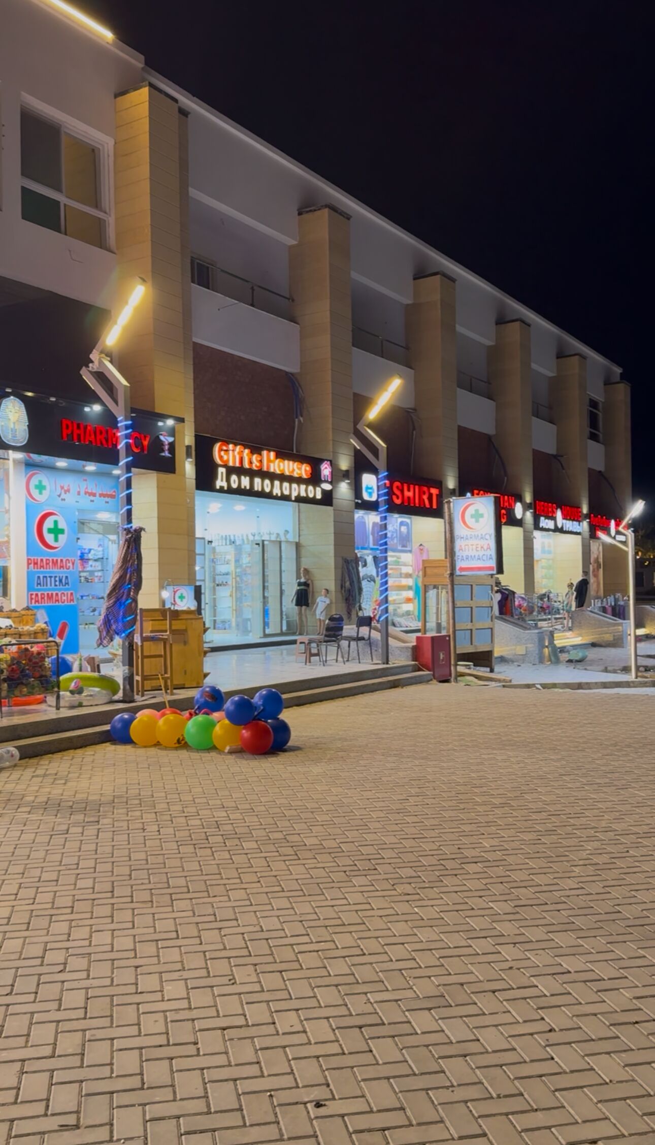 A multi-story building with various storefronts, including a pharmacy and a gift shop.