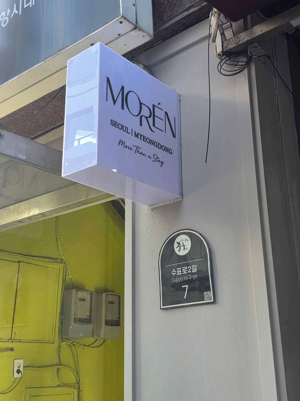 A sign for 'MORÉN' in Seoul, indicating a location for 'More Than a Stay'.
