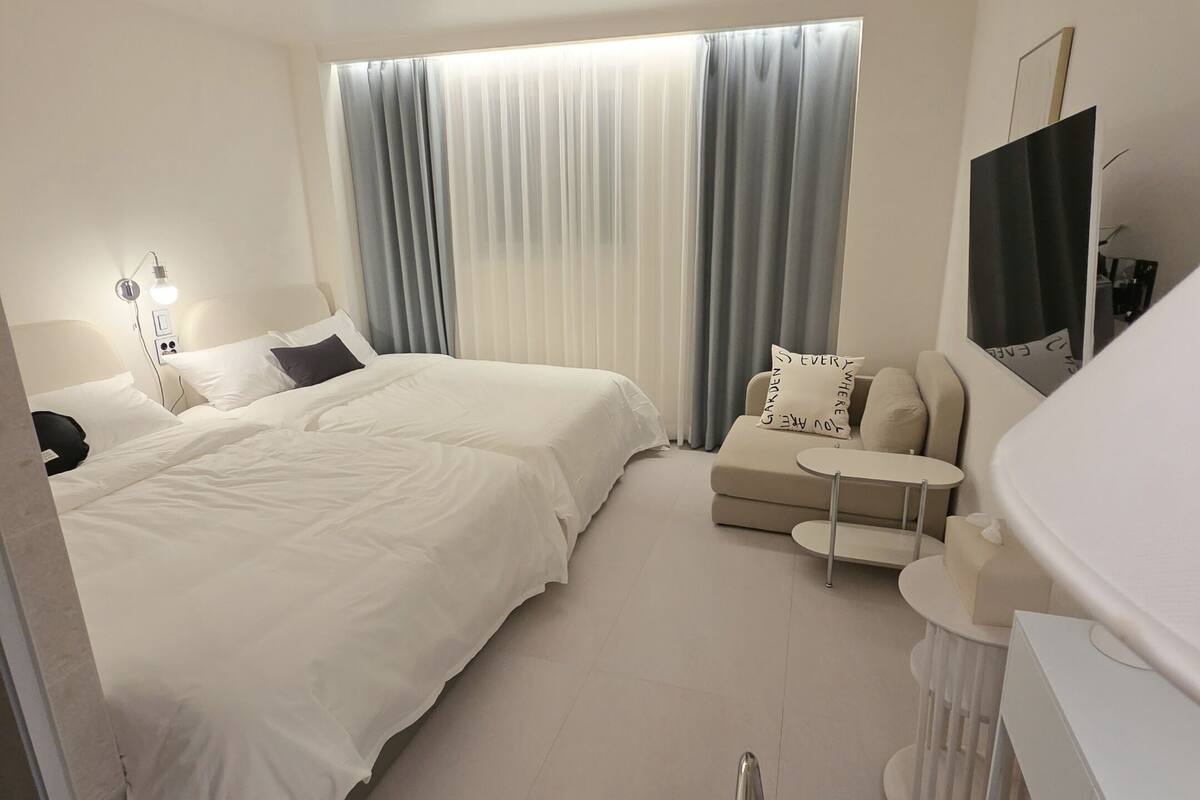 Een moderne hotelkamer met een groot bed, een sofa, een bureau en een televisie.