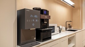Een moderne koffieapparaat en magnetron op een aanrecht.