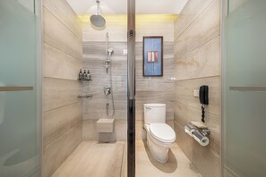 Une salle de bain moderne avec une douche à parois de verre, des toilettes et un sèche-mains.