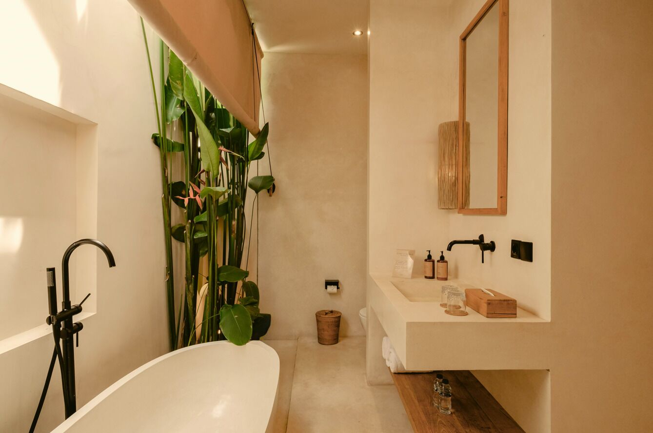A modern bathroom with a freestanding bathtub, a large mirror, and a sink with toiletries.