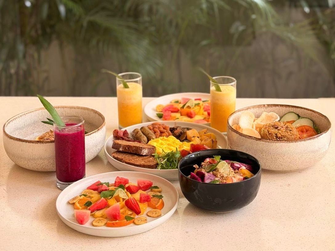 Una mesa con diversos platos y bebidas para el desayuno.