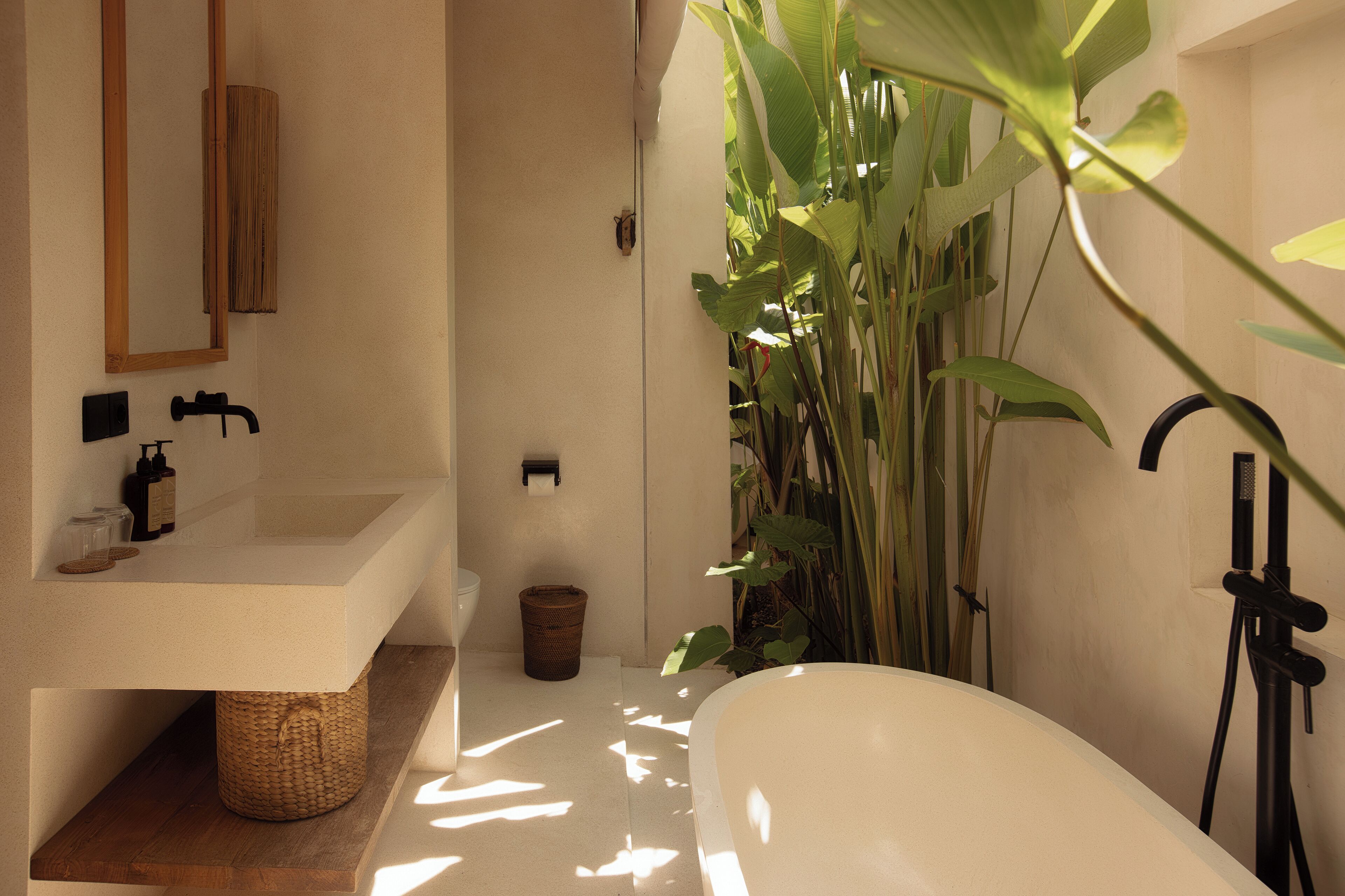 Un bagno moderno con una vasca freestanding, uno scaffale in legno, un lavandino e uno specchio.
