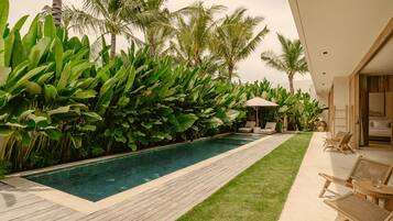 Een binnenzwembad, ligstoelen bij het zwembad