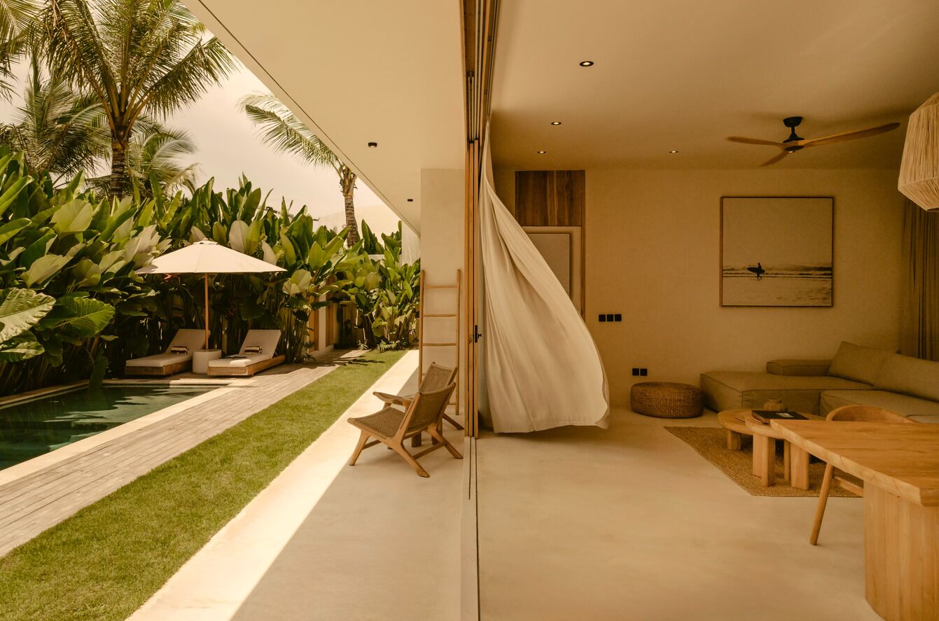 A modern indoor space with a pool, lounge chairs, and a dining area.