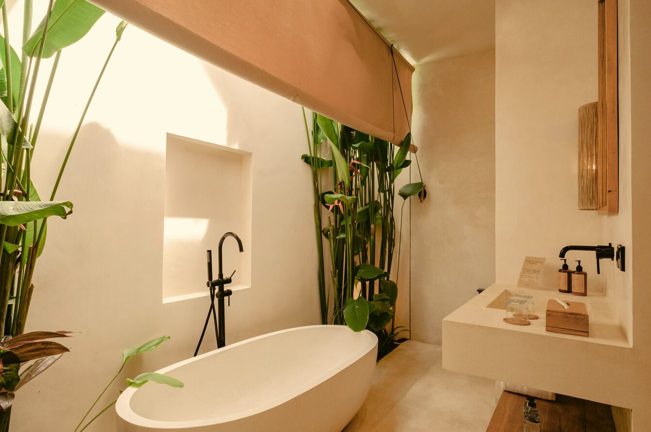 A modern bathroom with a freestanding bathtub, a vanity with a mirror, and various toiletries.
