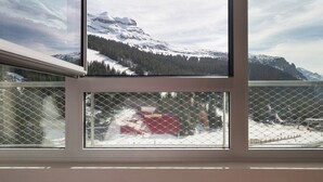 A room with a large window overlooking a snowy mountain landscape. - MGM Hôtels et Résidences - Hotel Alhena (Magland)