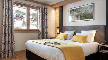 Una habitación de hotel moderna con una cama grande, una mesita de noche y una ventana con cortinas.