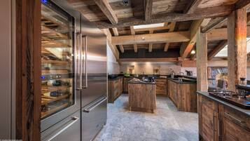 A modern kitchen with wooden beams, a stainless steel refrigerator, and a central island.