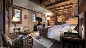 Una camera da letto accogliente in stile baita, con un letto grande, una scrivania e una poltrona.