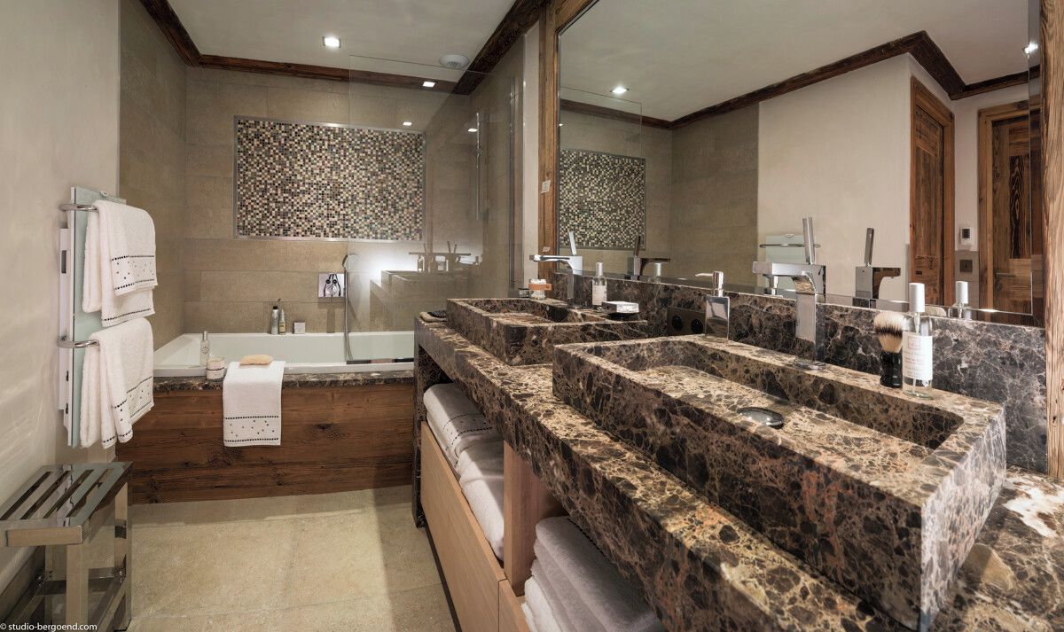 Un baño moderno con una bañera grande, un lavamanos doble y un espejo amplio.