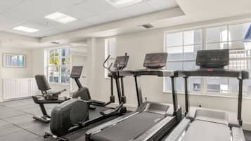 A gym with treadmills, elliptical machines, and a stationary bike.