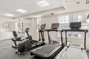 A gym with treadmills, elliptical machines, and a stationary bike. - Aloha Fridays Miami Beach (Bal Harbour)