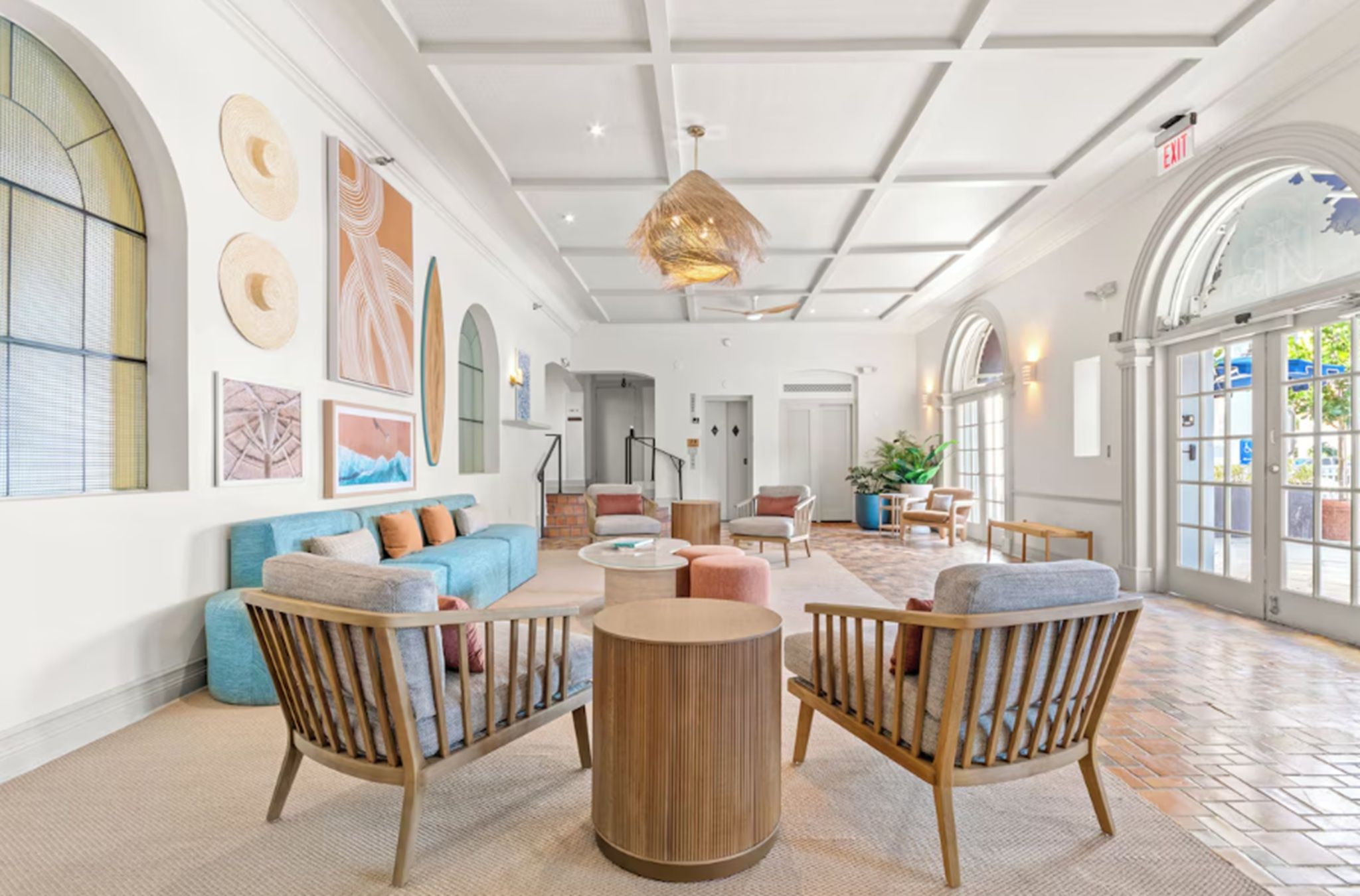A spacious lobby with a high ceiling, large windows, and a mix of seating areas including sofas and chairs.