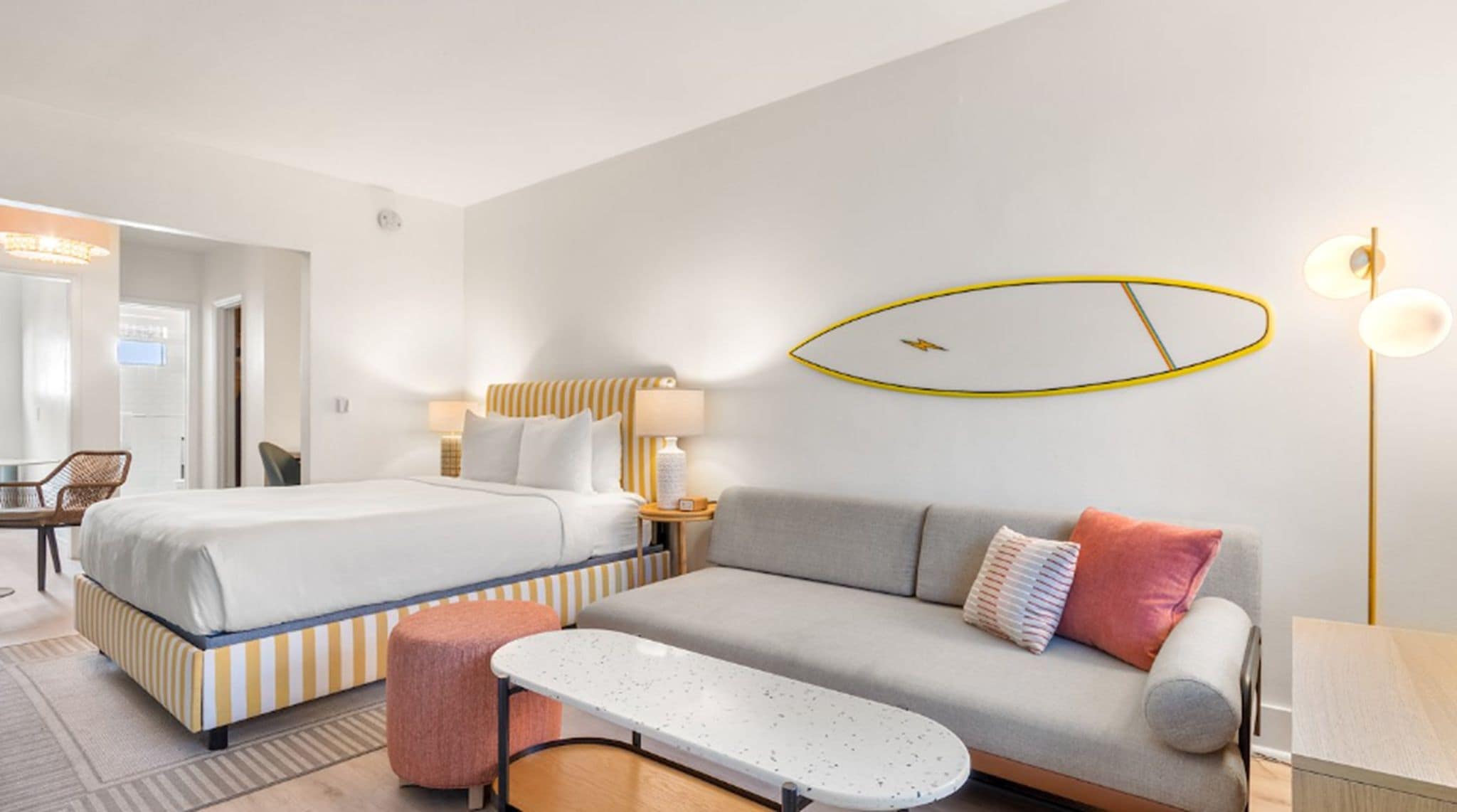 A hotel room with a bed, a sofa, a small table, and a chair.