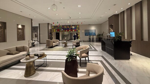 A modern lobby with a reception desk, seating area, and a staircase leading to upper floors. - 81 Newport Boulevard Across Naia T3 Airport (Pasay)