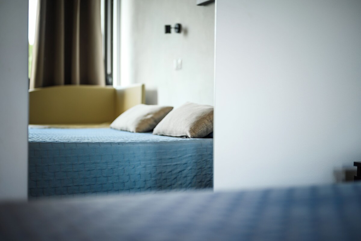 Una cama con un colchón azul y dos almohadas.