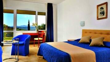 Una camera d'albergo con un letto, una scrivania, una sedia e vista sull'esterno.