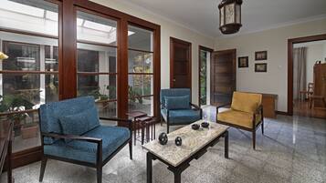 A spacious room with large windows, a wooden table, and two chairs.