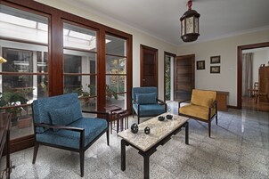Una habitación amplia con ventanas grandes, una mesa de madera y dos sillas.