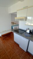 Una cocina compacta con una encimera, lavavajillas integrado y un tostador.